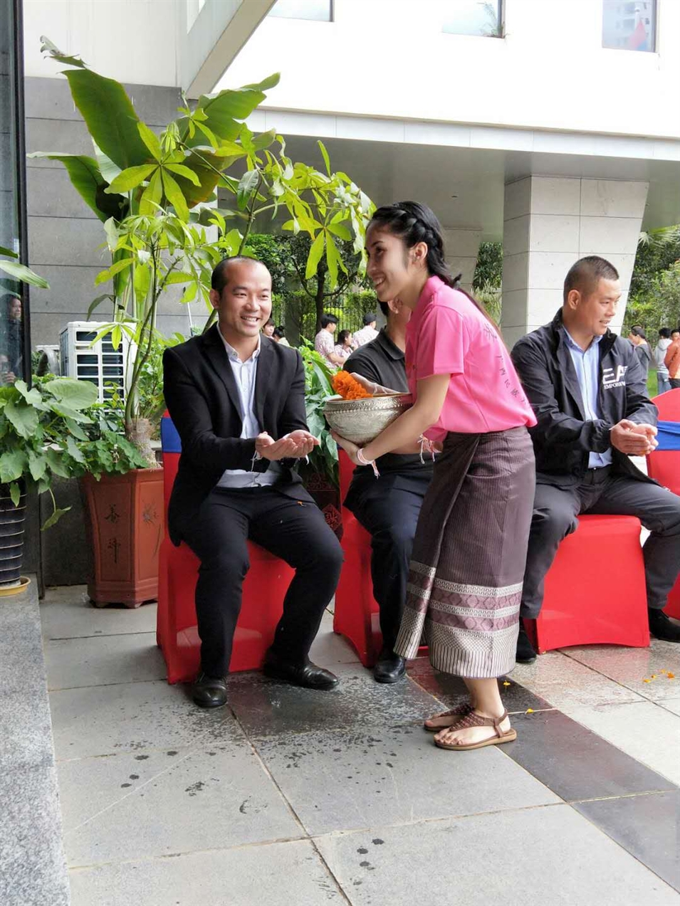 老撾駐廣西留學(xué)生代表將浸有花瓣的香水灑客人的手上，表示對(duì)嘉賓的美好祝福（圖一）
