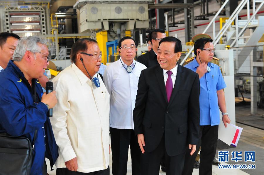 3月10日，在老撾沙灣拿吉省車邦縣，老撾人民革命黨中央總書記、國家主席本揚(yáng)（左二）在山東太陽紙業(yè)股份有限公司董事長李洪信（右二）的陪同下視察公司。 新華社記者章建華攝